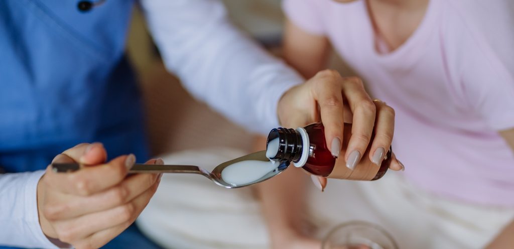 امرأة تعطي طفلتها الدواء