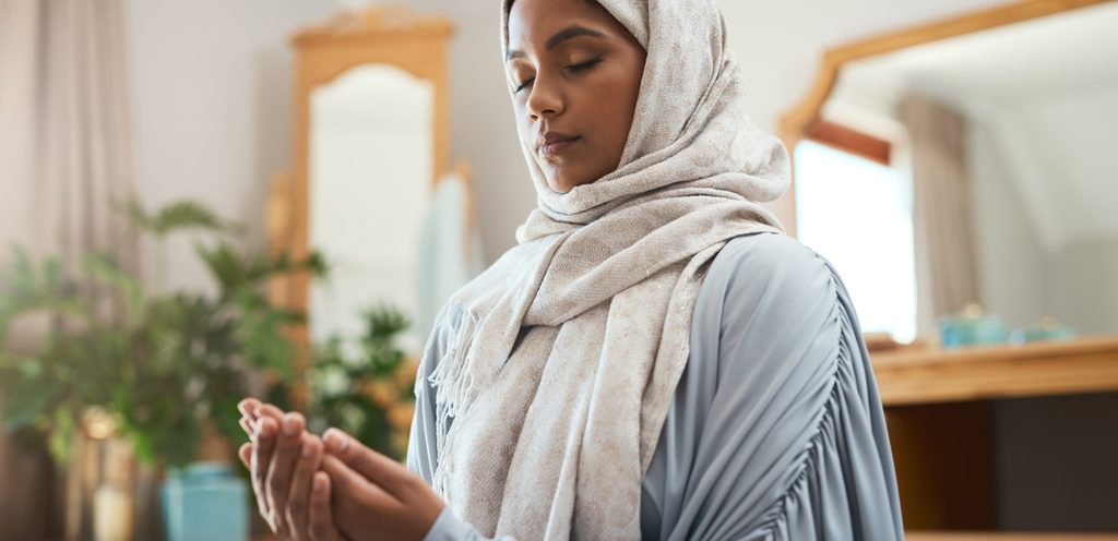 امرأة ترفع يديها للدعاء