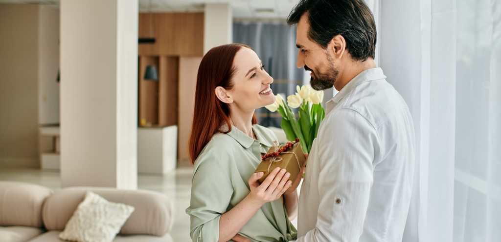 امرأة تمسك هدية وورود مُقدَّمة من زوجها