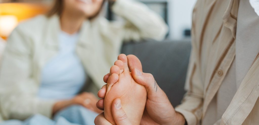 رجل يُدلّك قدم زوجته