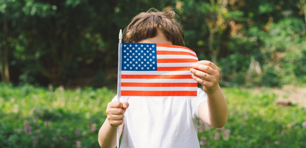 طفل يمسك العلم الأمريكي