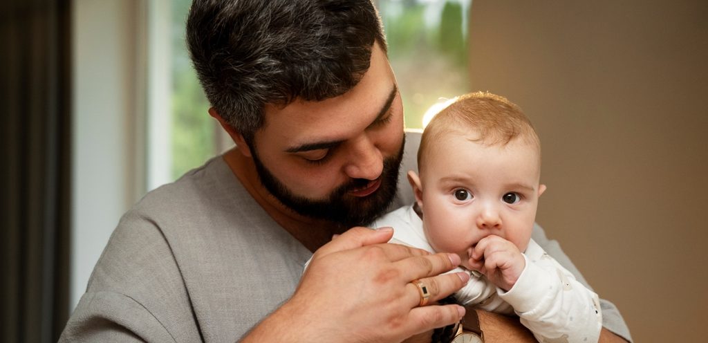 رجل يحمل طفل رضيع