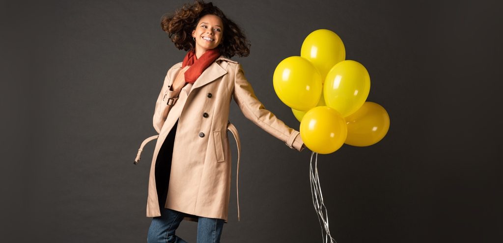 امرأة سعيدة تمسك بالونات صفراء