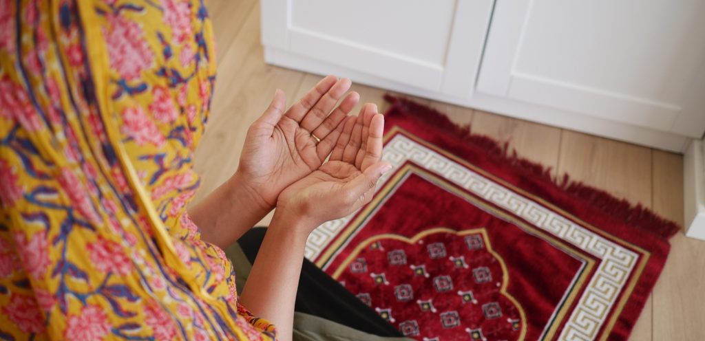امرأة ترفع كفّيها للدعاء