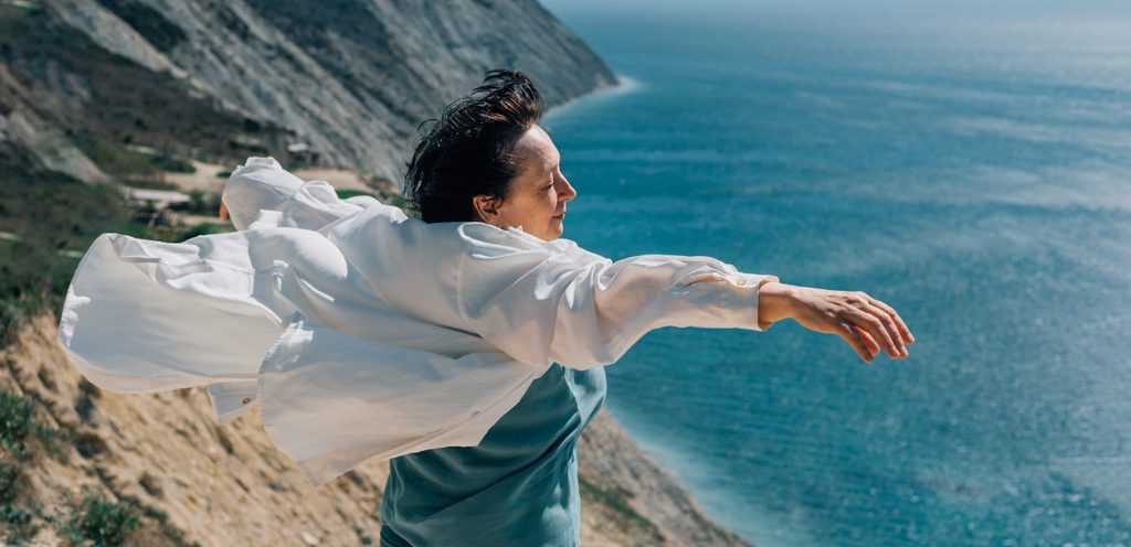 امرأة سعيدة تفتح يديها في الهواء