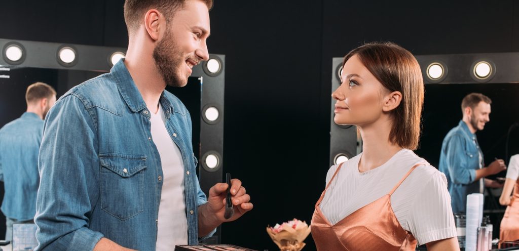 رجل خبير تجميل ينظر إلى امرأة عن قرب وبسعادة