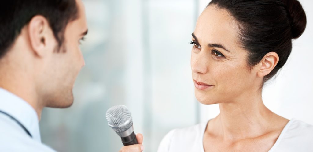 امرأة توجه مايكروفون لرجل