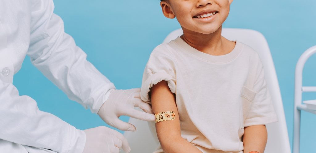 ممرّضة تضع ضماضة على يد طفل