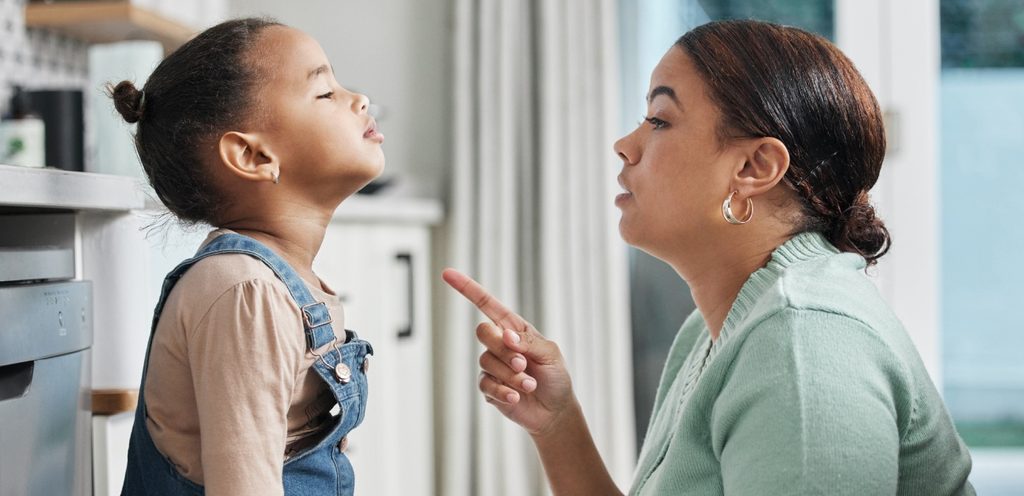 امرأة ترفع إصبعها في وجه طفلتها