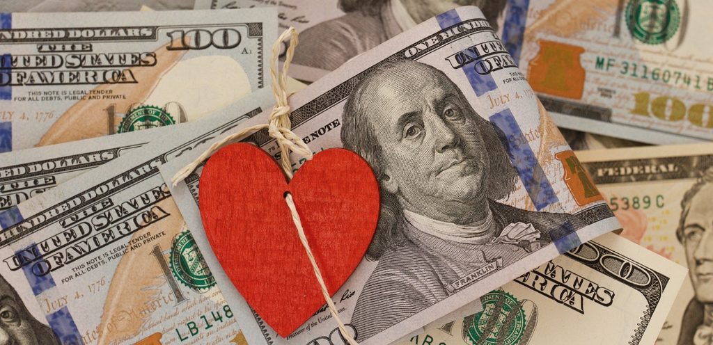 نقود بعملة الدولار وقلب أحمر