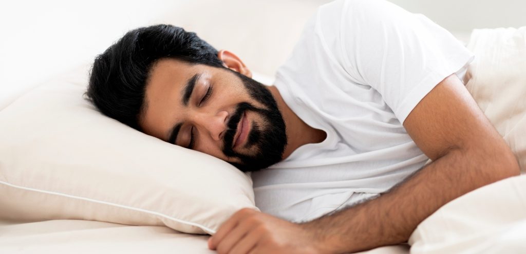 رجل سعيد نائم في السرير