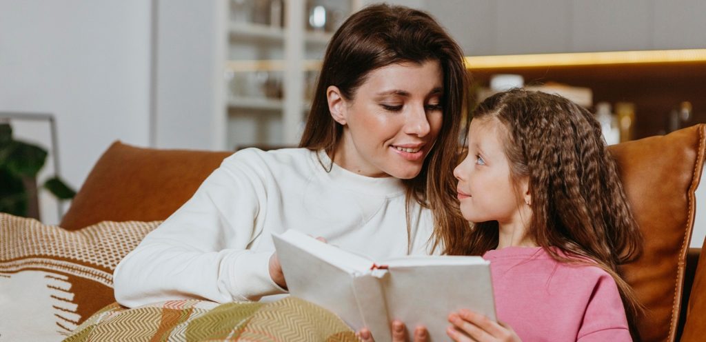 أم وطفلتها تقرآن كتاب