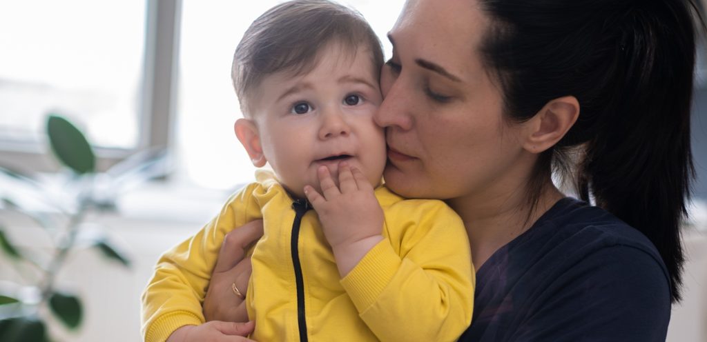 امرأة تقبّل طفلها