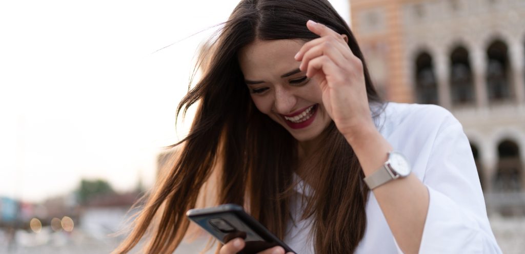 امرأة سعيدة تنظر إلى هاتفها