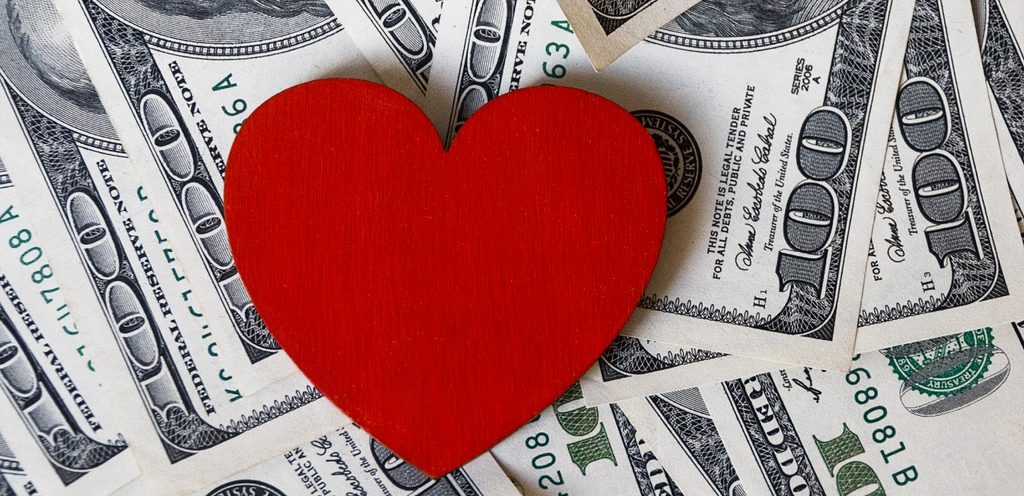 نقود بعملة الدولار وقلب أحمر