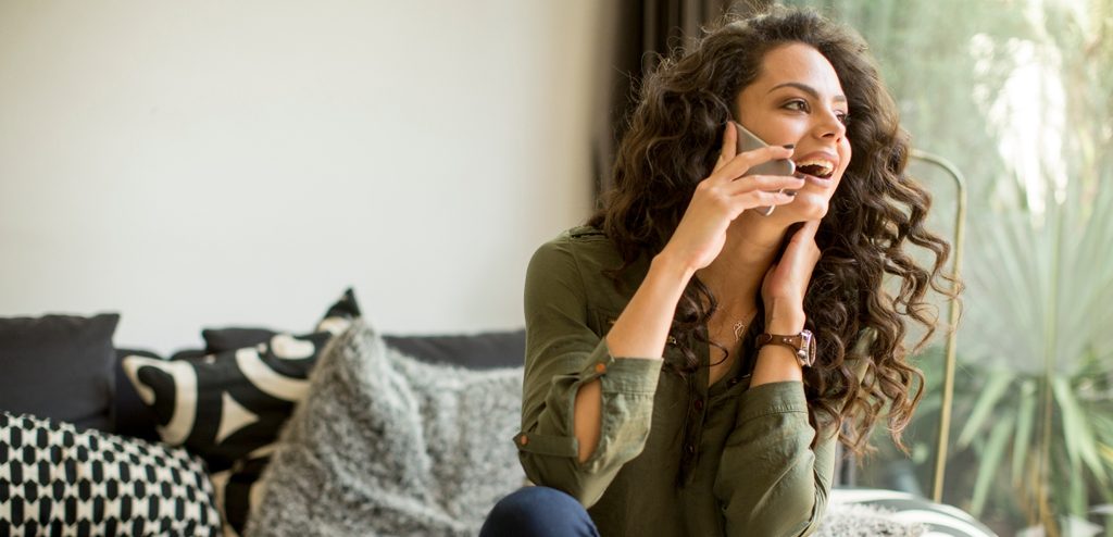 امرأة سعيدة تتكلّم على الهاتف