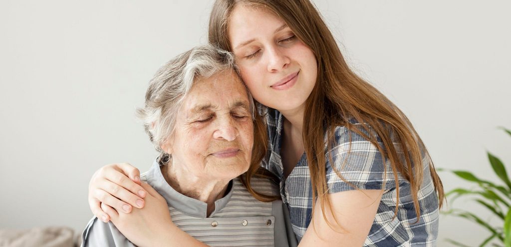 امرأة شابّة تعانق امرأة مسنّة