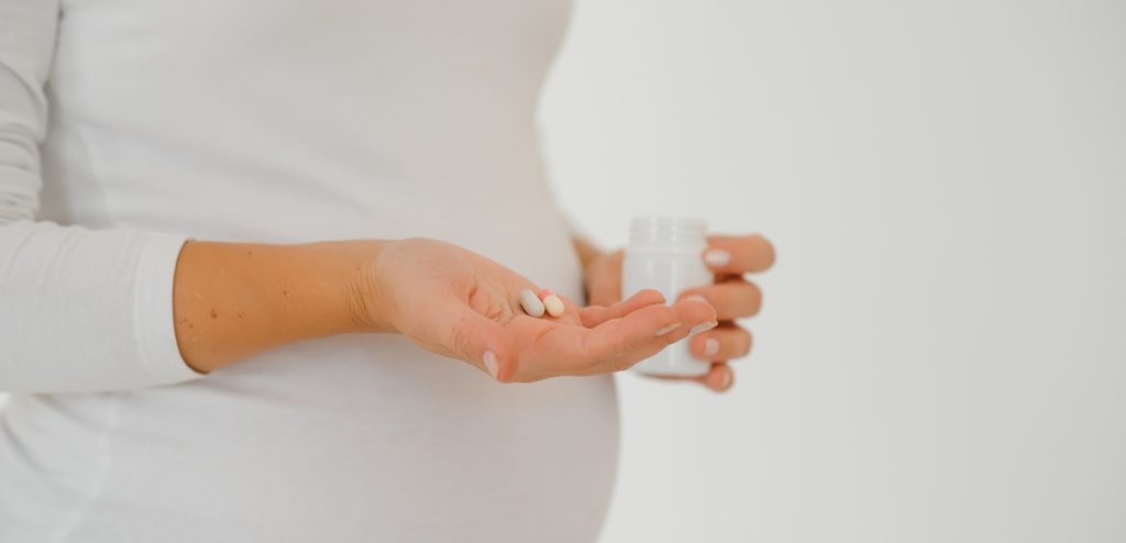 امرأة حامل تمسك حبوب من الدواء