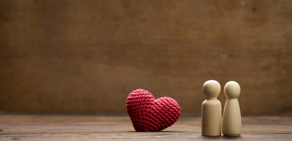 مجسّم مصغّر لشخصين وخلفهما قلبًا أحمرًا