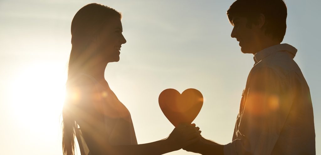 امرأة ورجل يمسكان شكل قلب
