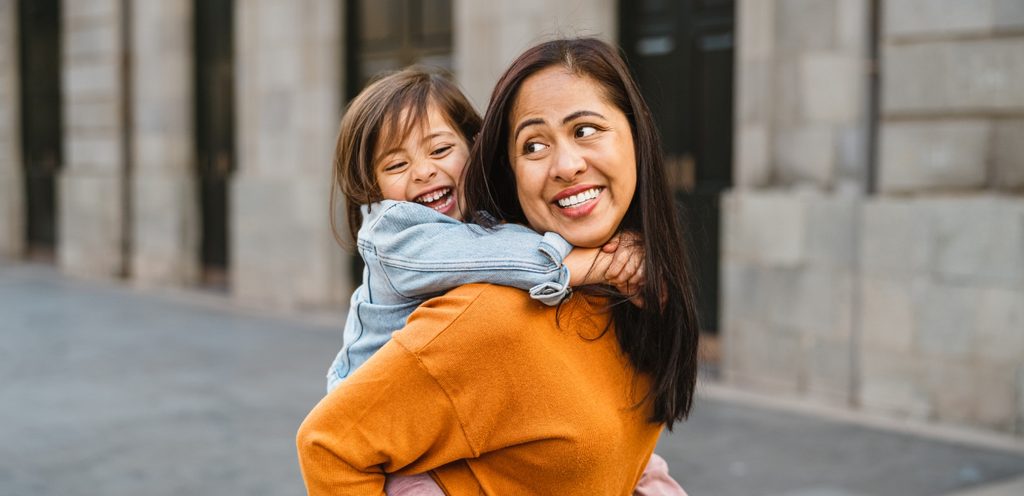 امرأة تحمل طفلتها على كتفيها