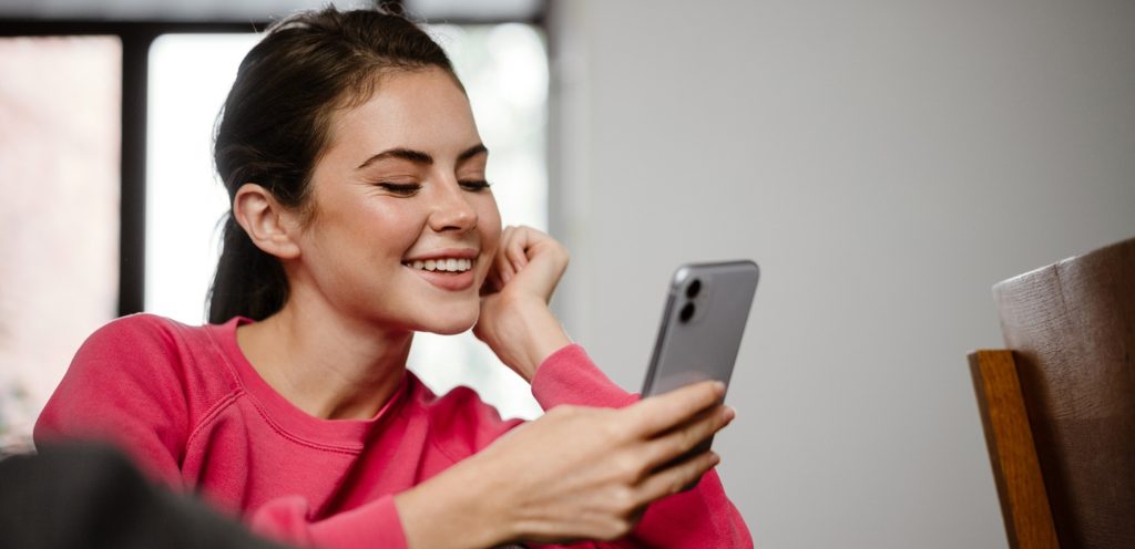 امرأة سعيدة تنظر إلى هاتفها