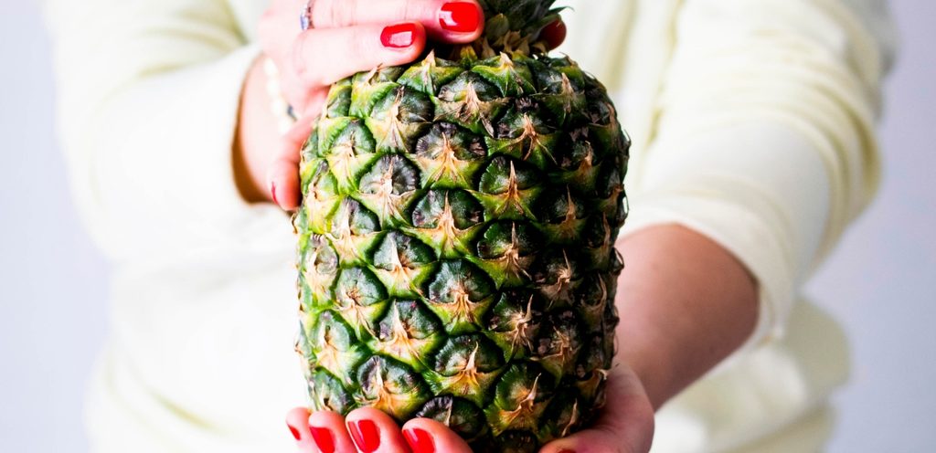 امرأة تمسك  ثمرة أناناس