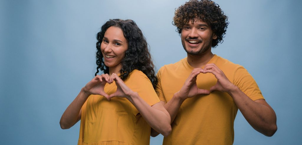 زوجان سعيدان يصنعان قلبين بيديهما