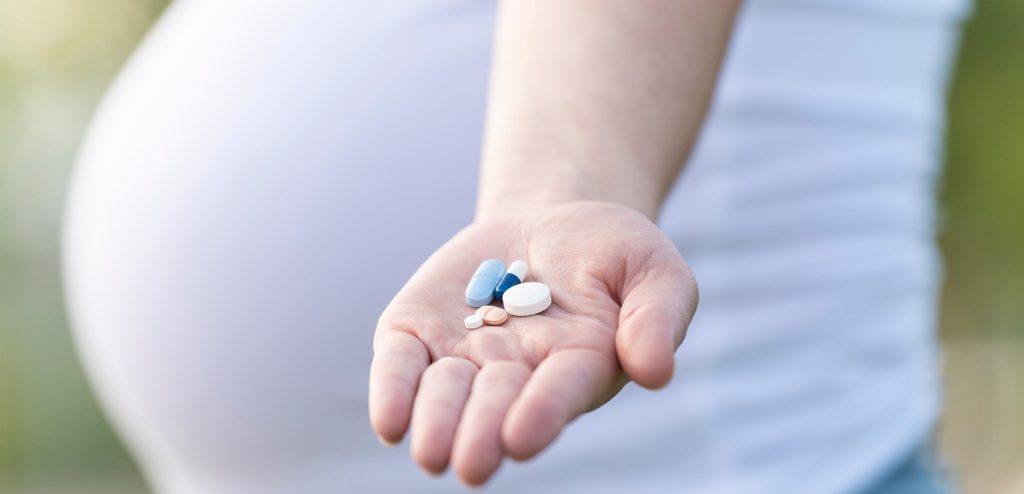 امرأة حامل تمسك حبوب من الدواء