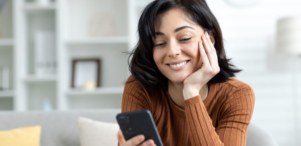 امرأة سعيدة تنظر إلى هاتفها