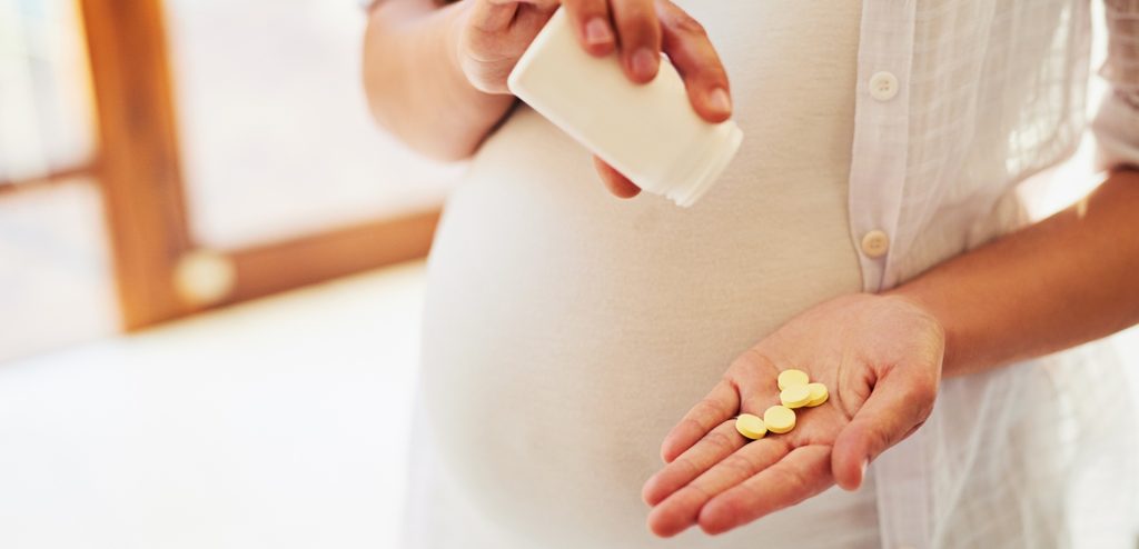 امرأة حامل تمسك حبوب من الدواء