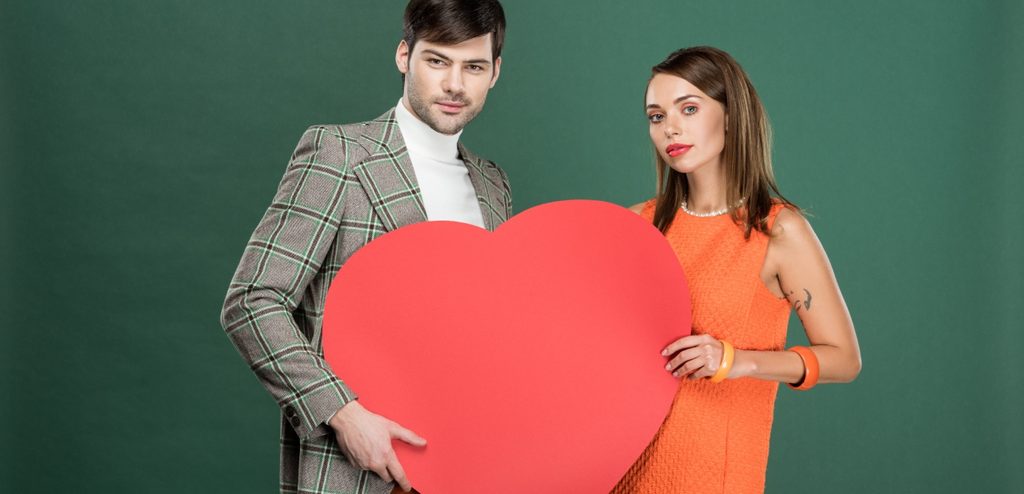 امرأة ورجل يمسكان قلبًا أحمرًا كبيرًا