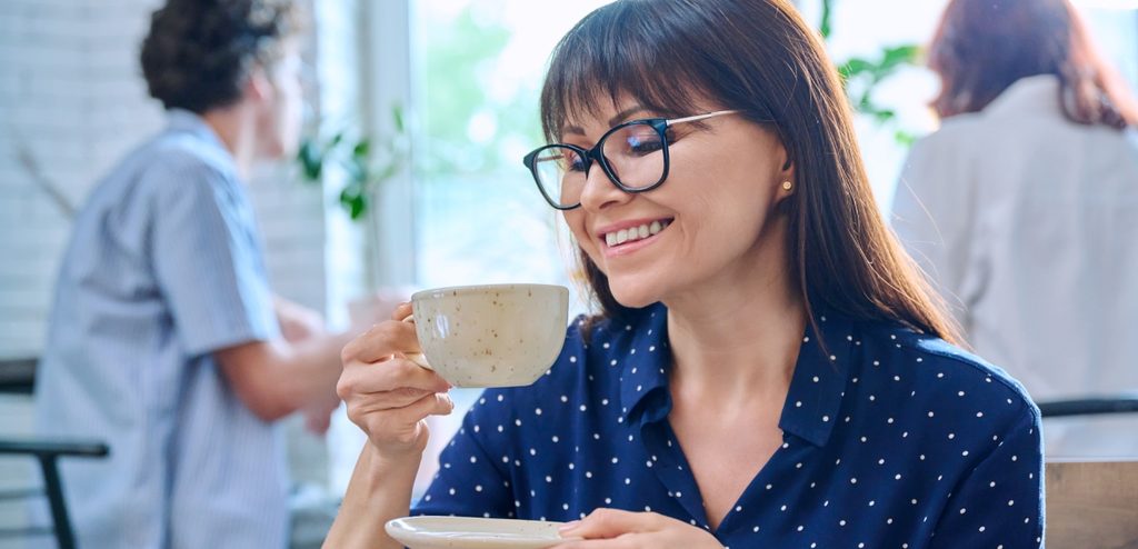 امرأة سعيدة تمسك فنجان من القهوة