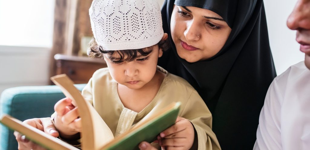 امرأة تقرأ القرآن مع طفلها