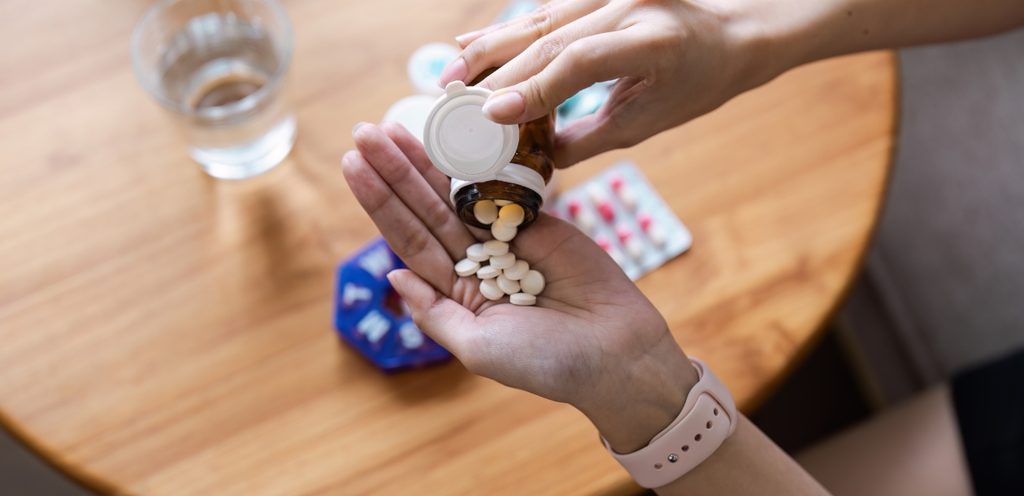 امرأة تمسك حبوب دواء