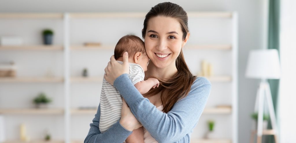 أم تحمل طفلها بسعادة