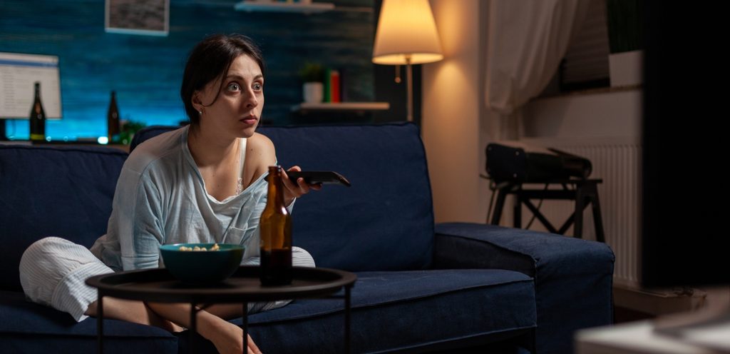 امرأة تمسك جهاز التحكّم