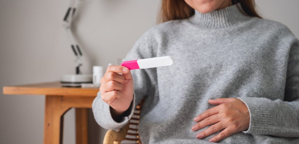 امرأة تمسك اختبار حمل