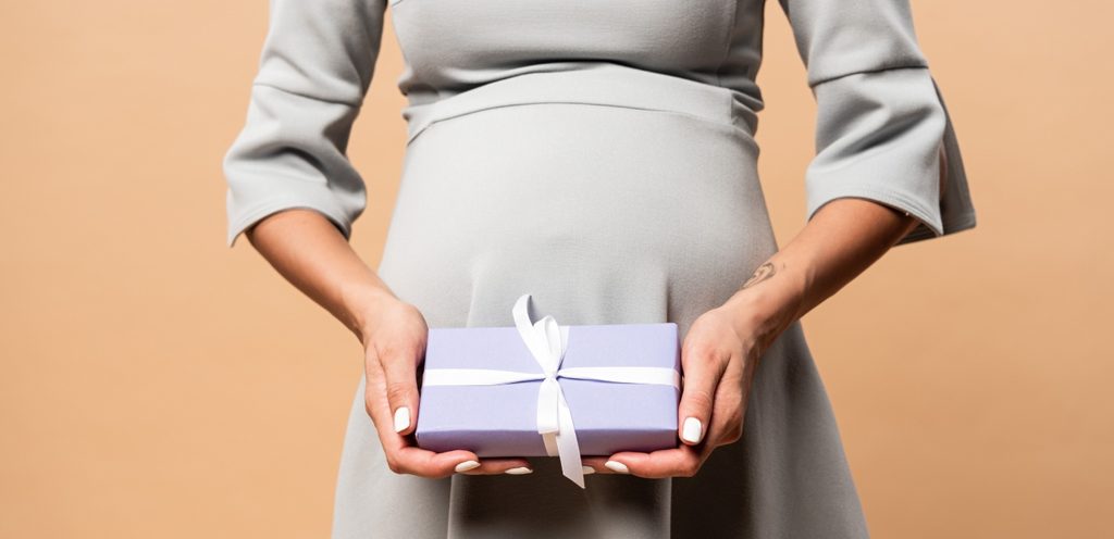امرأة حامل تمسك هدية