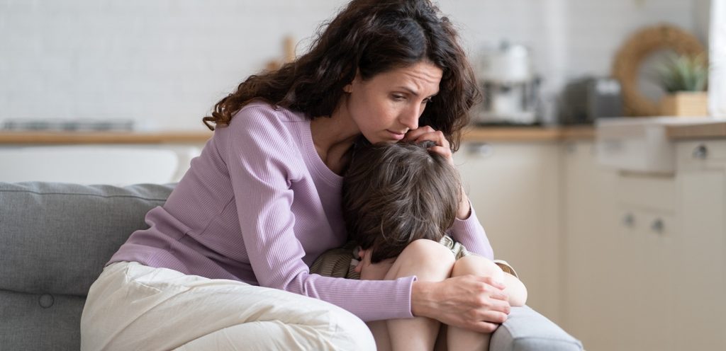 امرأة تعانق طفلها الحزين