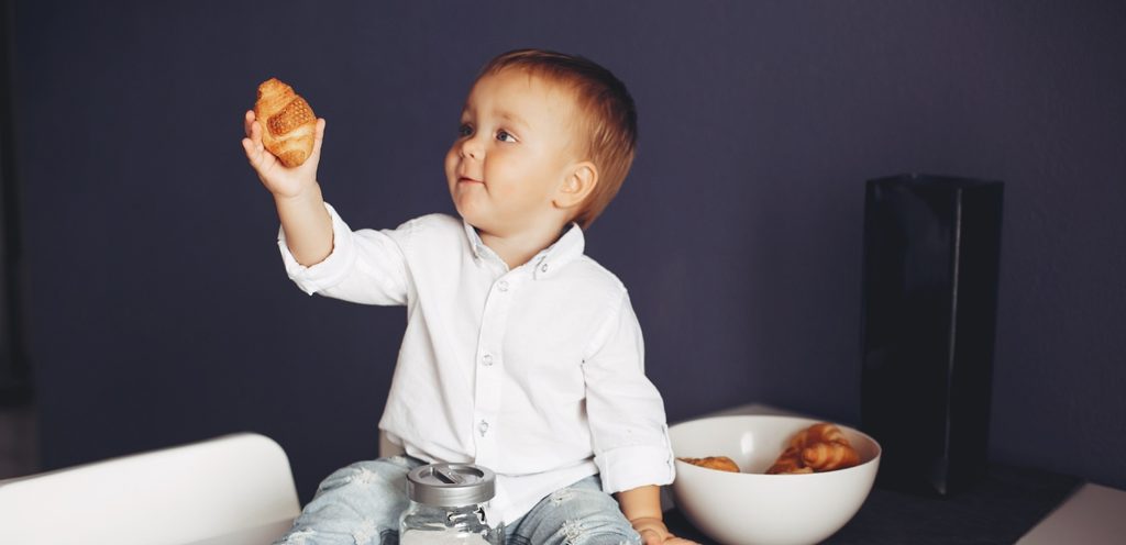 طفل رضيع يمسك كرواسون