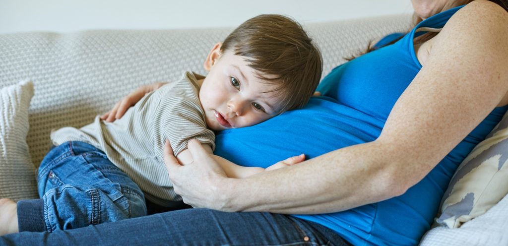 امرأة حامل وطفلها يعانق بطنها