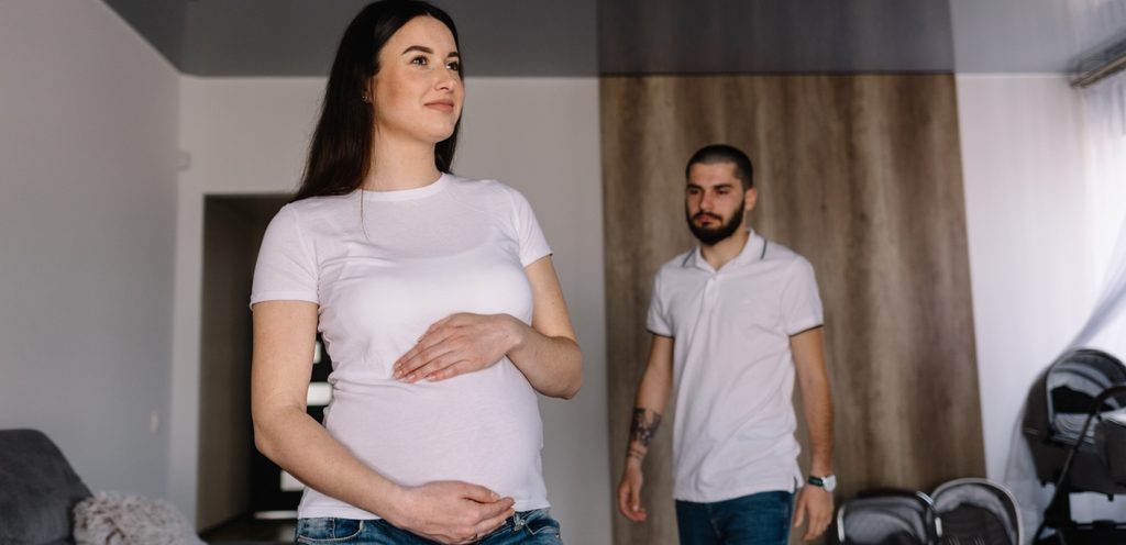 امرأة حامل وزوجها خلفها