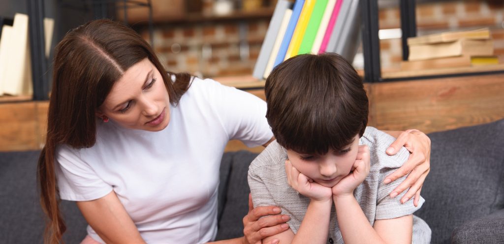 طفل حزين ووالدته تواسيه