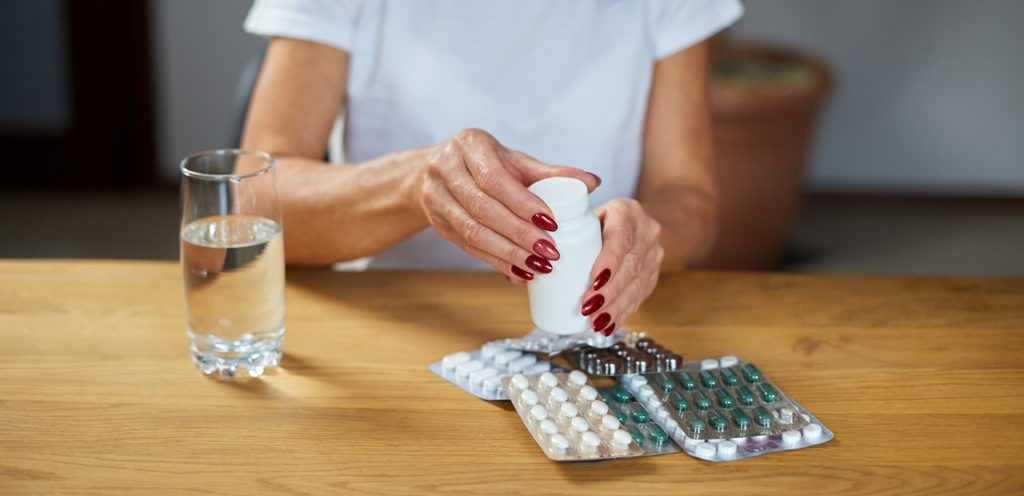 امرأة تمسك حبوب دواء