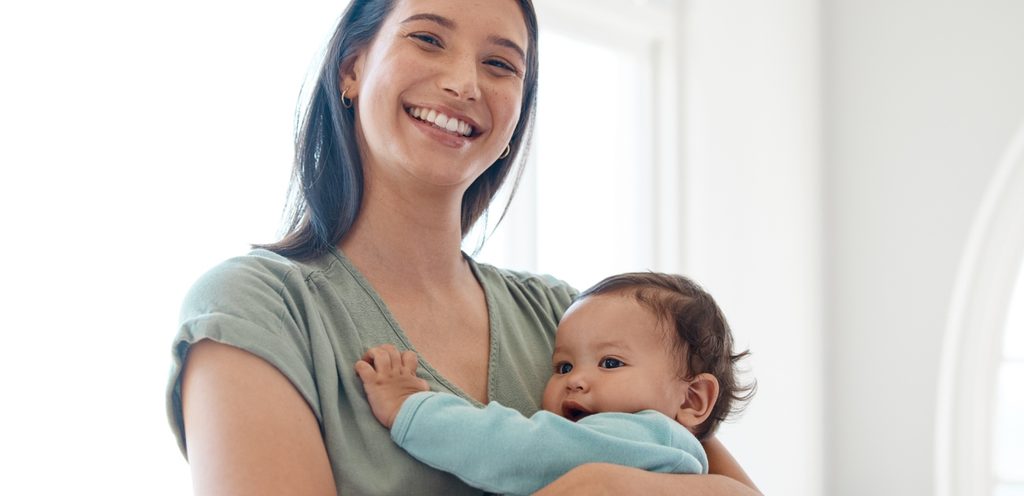 أم تحمل طفلها بسعادة