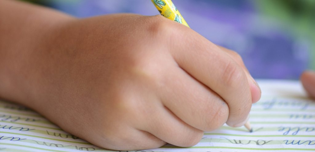 طفل يكتب على الدفتر