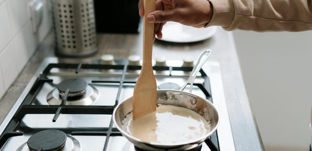 امرأة تستخدم ملعقة خشبيّة في الطهي