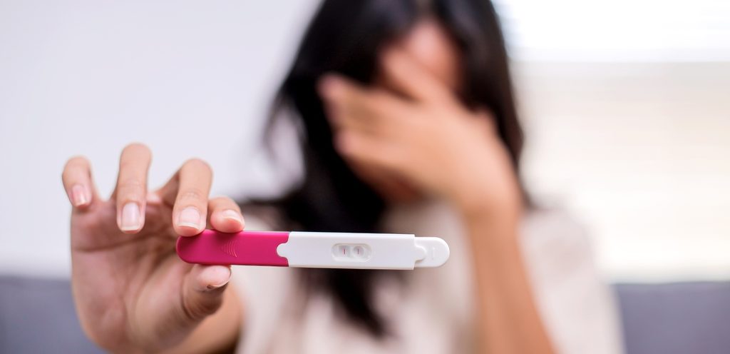 امرأة تمسك اختبار حمل