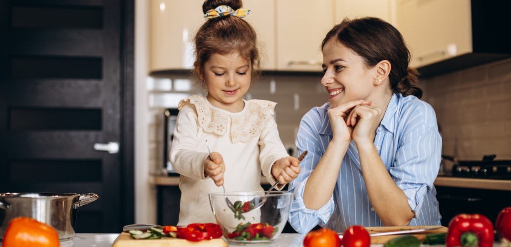 طفلة تساعد والدتها في إعداد الطعام